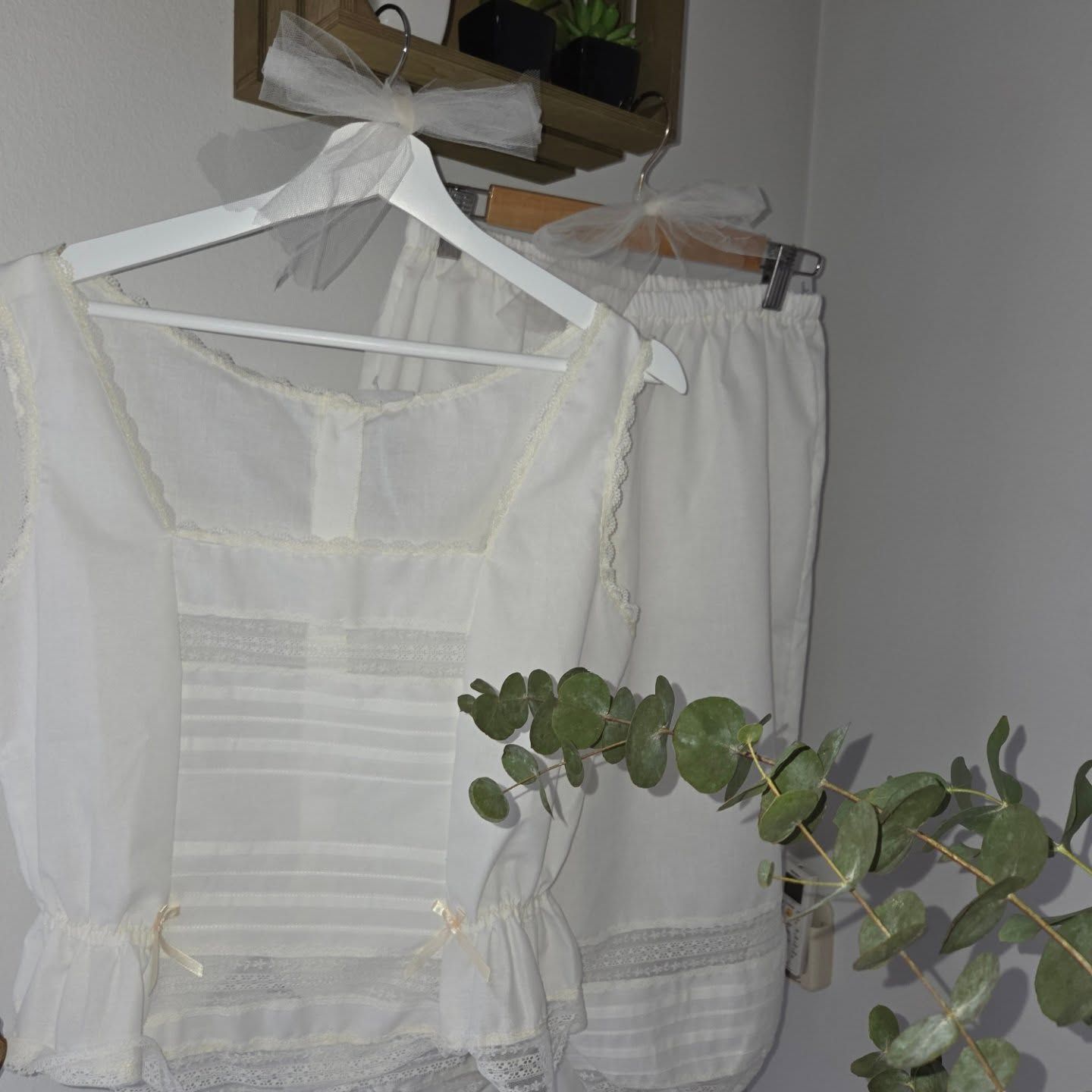 Blusas sin mangas con estampado floral colgadas en un perchero con etiquetas de precio.